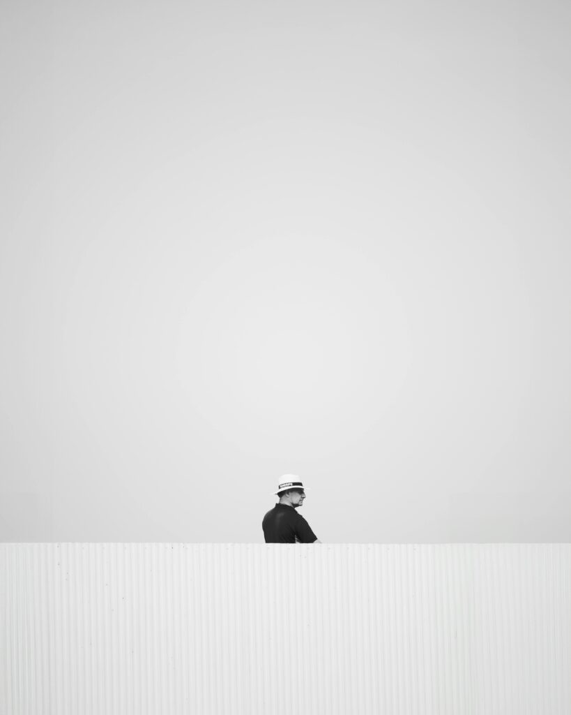 A minimalist black and white photo of a worker outdoors in Spain.